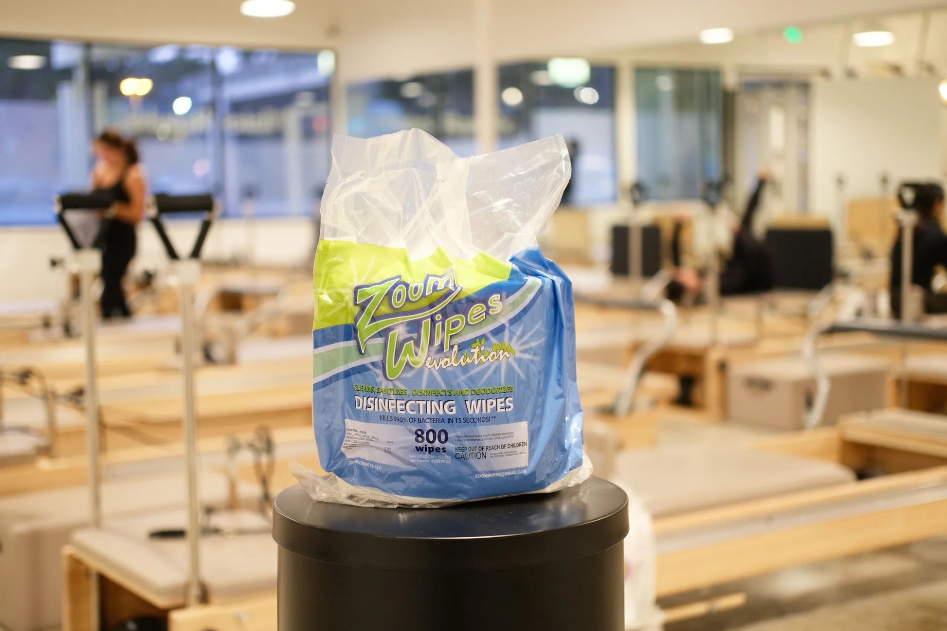 Disinfecting wipes in a blue and green package on a trash can