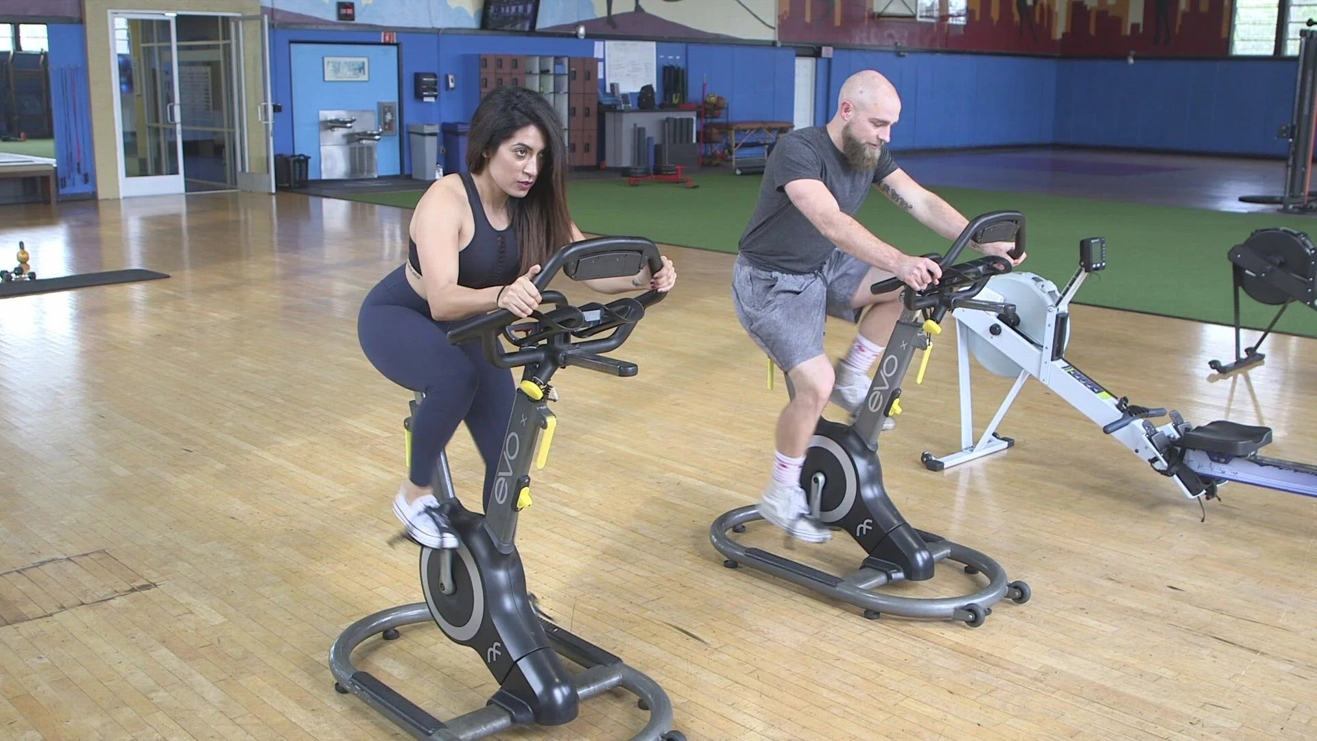 Indoor gym with two people on exercise bikes